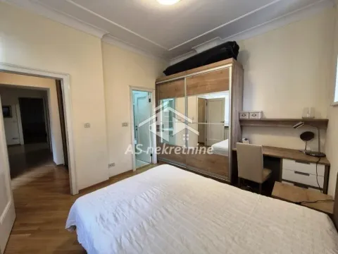 Furnished bedroom with a double bed, wardrobe, and a desk. - image 10