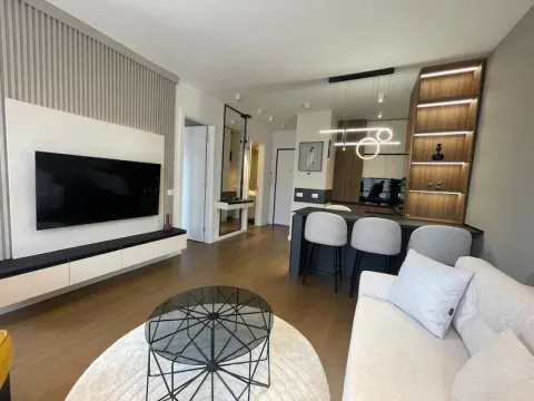 Modern living room with a sofa, television, and a dining area in the background. - image 8