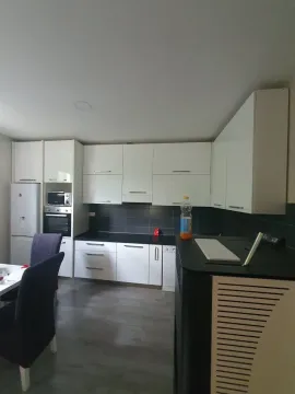 Kuhinja sa bijelim elementima i crnom radnom površinom. - image 8