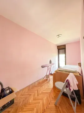 Manja spavaća soba sa krevetom, roze zidovima i parketom. - image 9