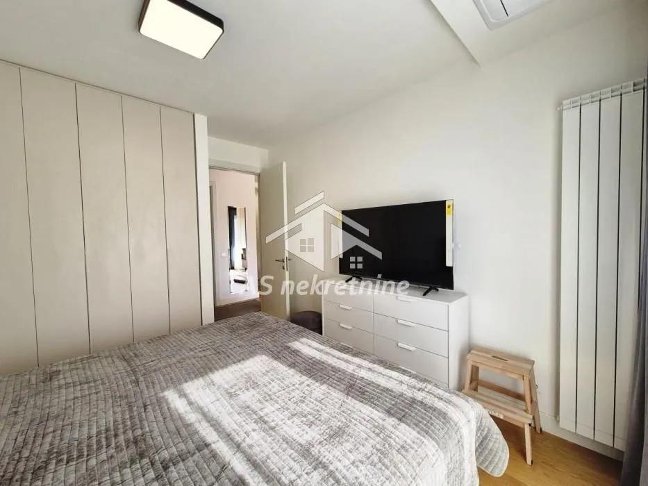 Bedroom with a double bed, wardrobe, and television.