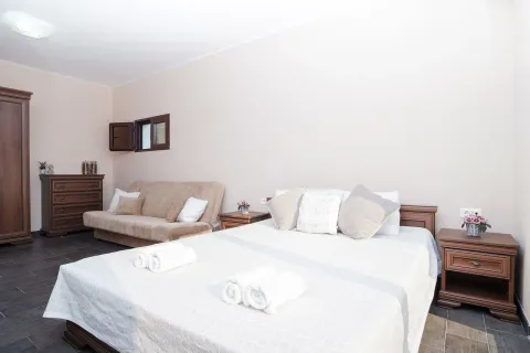 Furnished bedroom with a double bed, sofa, and chest of drawers. - image 13