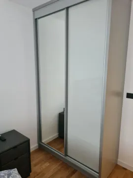 A modern wardrobe with sliding mirror doors in a bedroom. - image 8