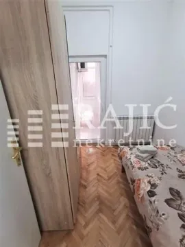 Smaller bedroom with a bed, wardrobe, and parquet flooring. - image 10