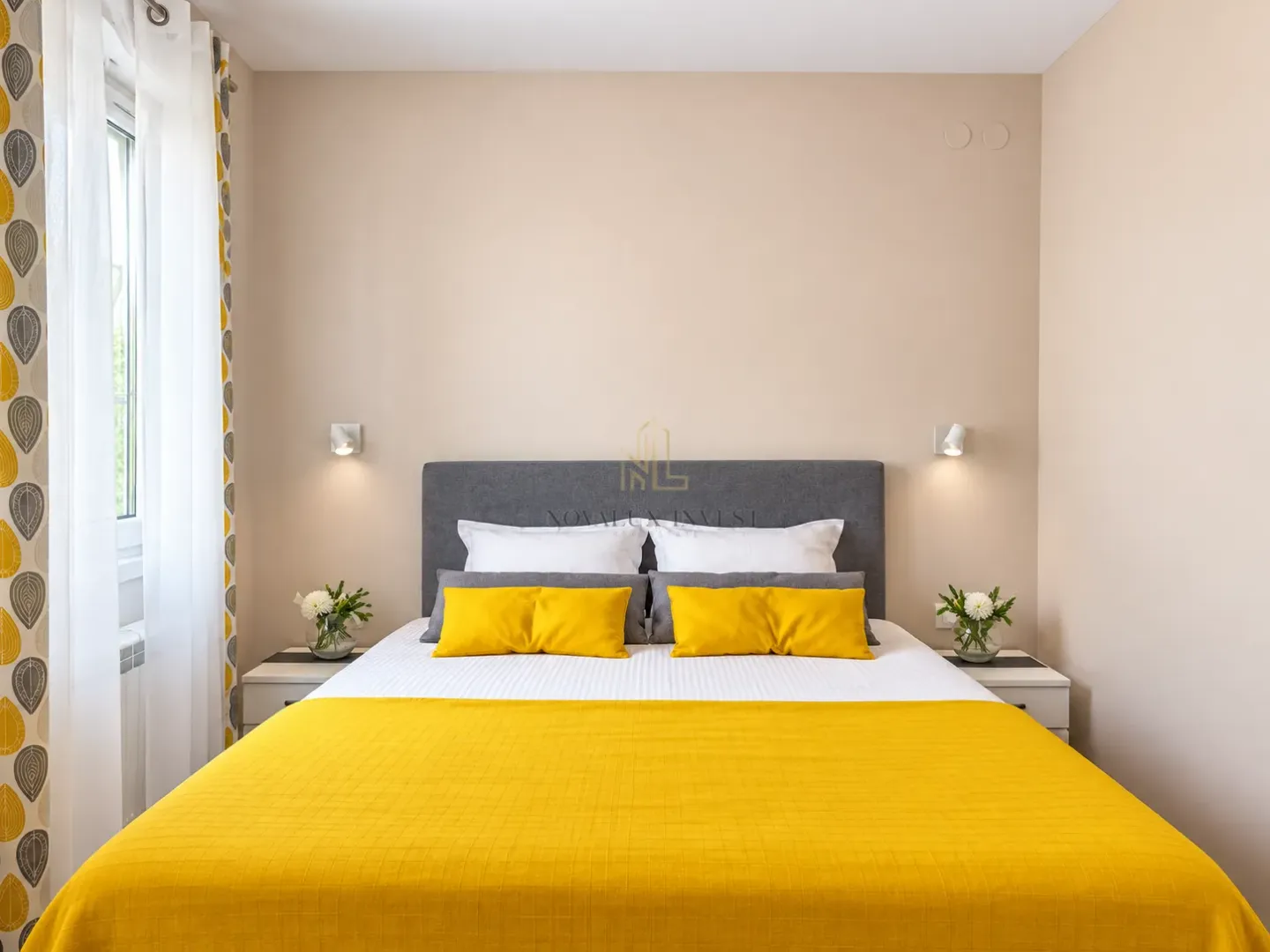 Bedroom with a double bed, grey headboard, and yellow details.