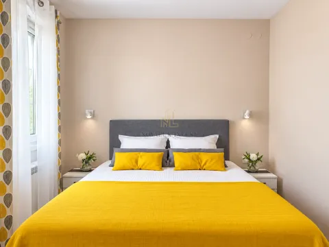 Bedroom with a double bed, grey headboard, and yellow details. - image 13