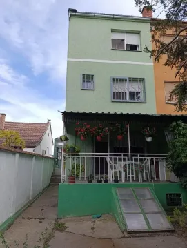 Pogled na spoljašnjost kuće sa zelenom fasadom, terasom i dvorištem. - image 12