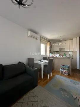 Dnevni boravak sa garniturom, trpezarijom i kuhinjom u pozadini. - image 12
