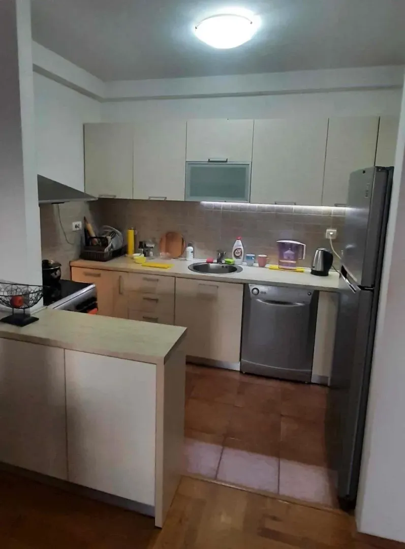 Smaller kitchen equipped with lower and upper cabinets and household appliances.