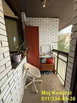 Natkriveni balkon sa belim ciglenim zidovima, stolicom i ostavom. - image 7