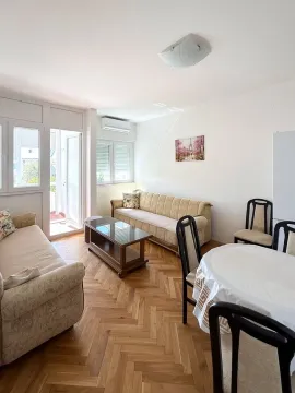 Living room with sofa seating, dining table, and balcony access. - image 10