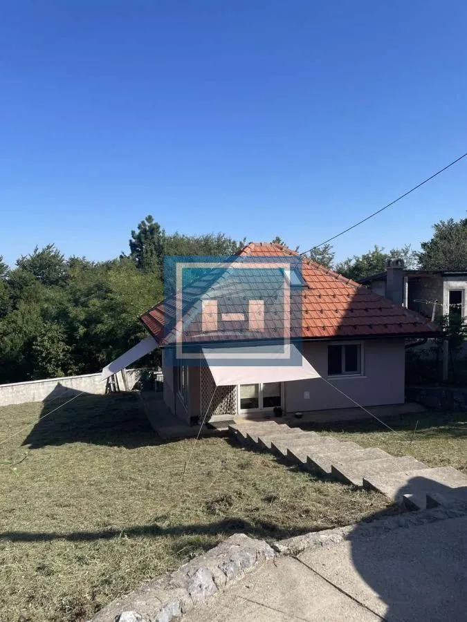 Exterior view of the house with a yard and stairs.