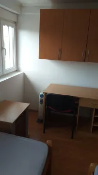 A study corner in a bedroom with a desk and cabinet. - image 3