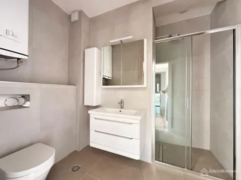 Savremeno opremljeno kupatilo sa tuš kabinom, umivaonikom i wc šoljom. - image 16