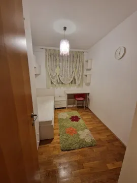 Mala spavaća soba sa jednim krevetom, radnim stolom i šarenim tepihom. - image 15