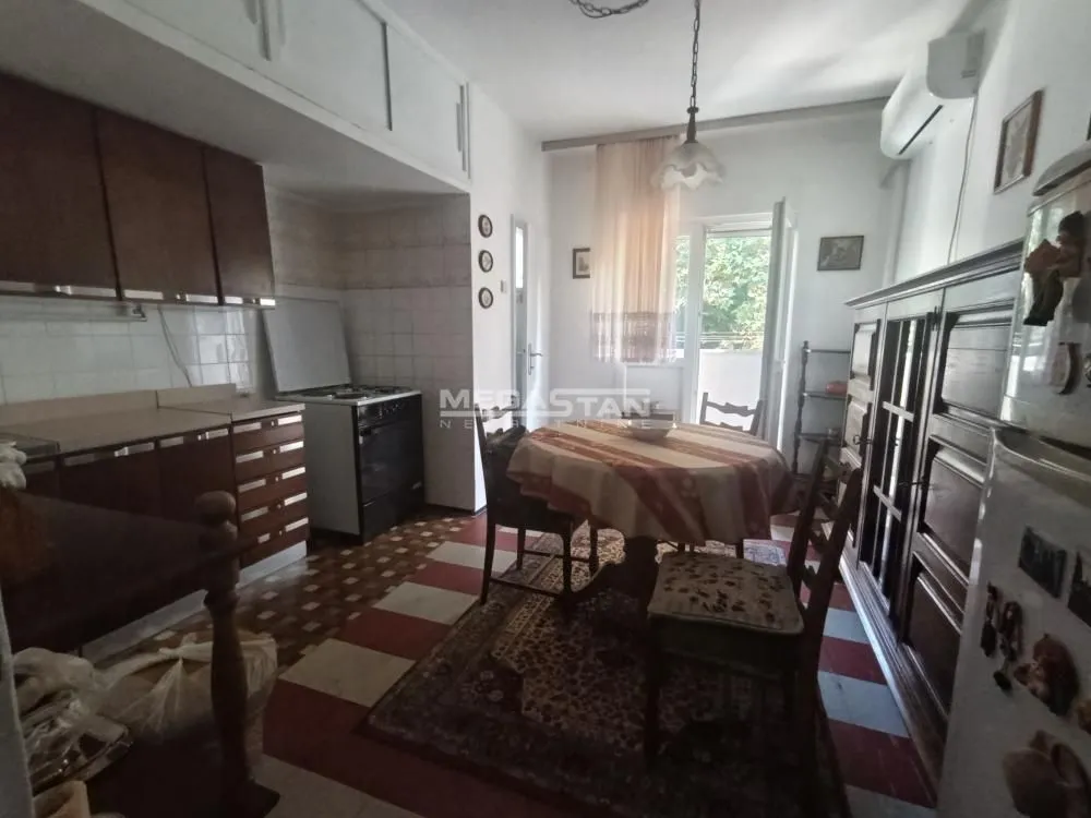 Older kitchen with a dining area and wooden furniture.
