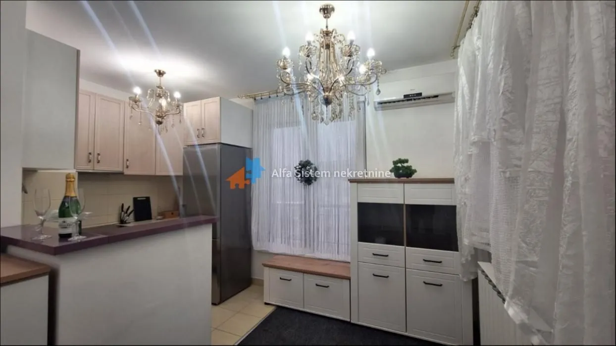 View of the kitchen with light-colored cabinetry and a dining area.