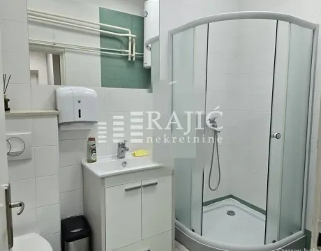 Small bathroom with a shower cabin, washbasin, and white tiles. - image 7