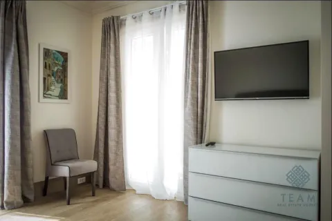 Dnevna soba sa televizorom na zidu, komodom i balkonskim vratima. - image 6