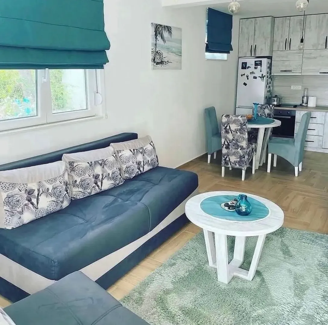 Living room with a sofa and dining area in an open-plan space.