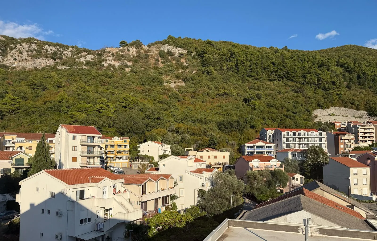 Pogled na stambene zgrade i brdo u pozadini.