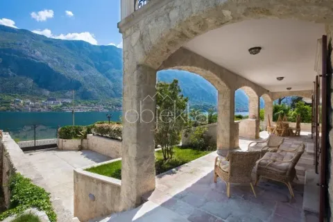 Covered stone terrace with seating furniture and views of the sea and mountains. - image 11