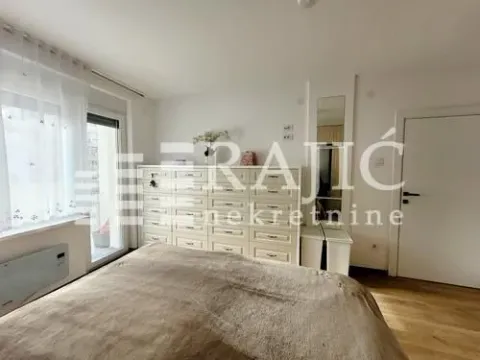 Furnished bedroom with a double bed, large chest of drawers, and balcony access. - image 10