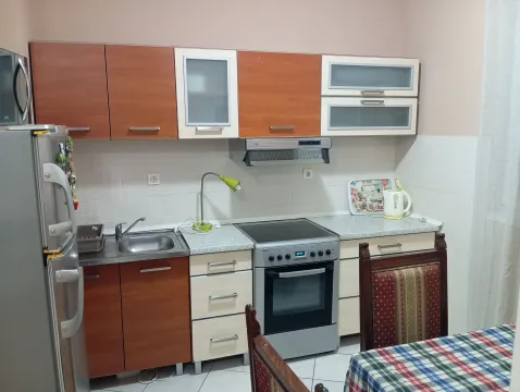 Manja kuhinja sa drvenim elementima, šporetom i frižiderom. - image 4