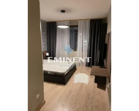 Furnished bedroom with a double bed, wooden flooring, and curtains. - image 9