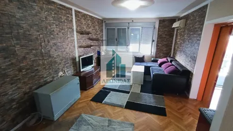 Dnevna soba sa garniturom za sedenje, televizorom i parketom na podu. - image 2