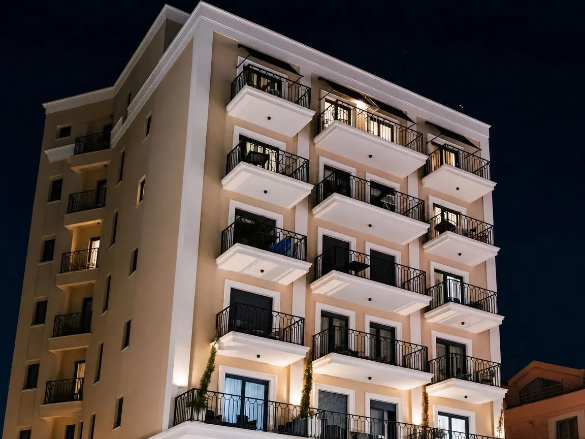 Night view of the exterior of a multi-story residential building with balconies and lighting.