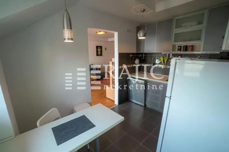 Smaller kitchen with a dining table and grey cabinets.