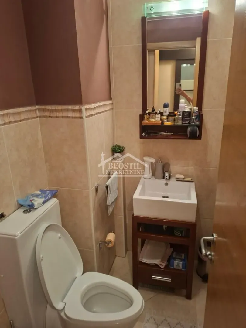 Manje kupatilo sa umivaonikom, ogledalom i wc šoljom.