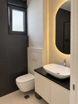 Moderno uređeno kupatilo sa umivaonikom i toaletom. - image 8