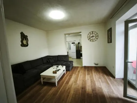 Living room with a sectional sofa, coffee table, and a view into the kitchen. - image 9