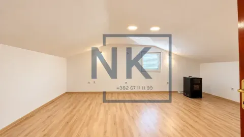 Empty attic room with wooden flooring and a wood-burning stove. - image 15