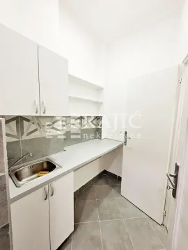 Smaller white kitchen with a sink and countertops. - image 5