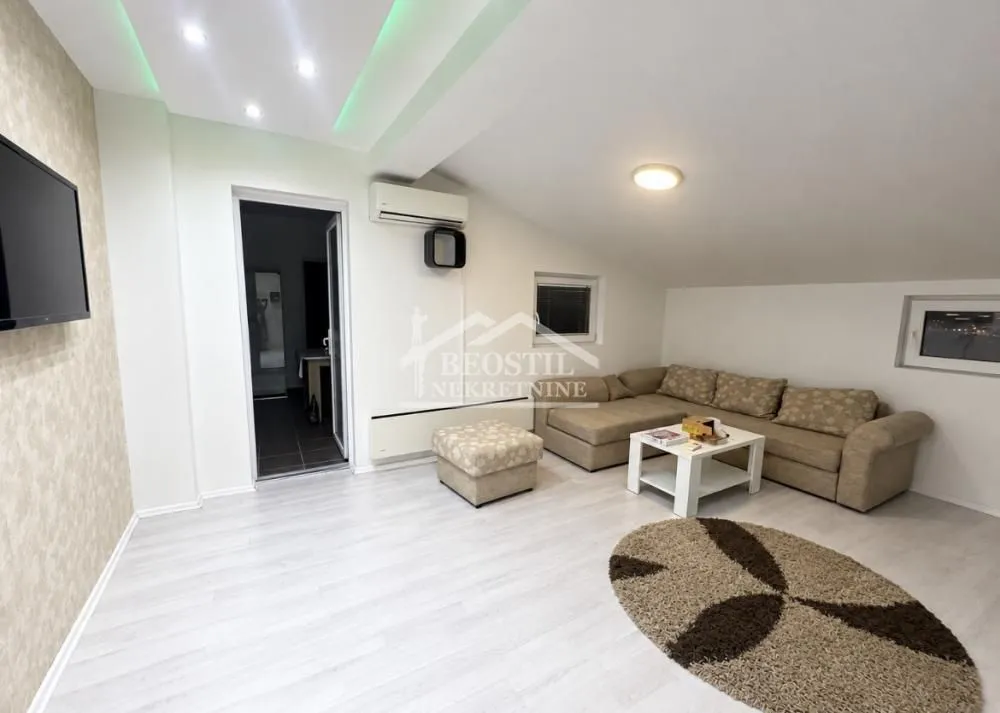 Living room with a sectional sofa, coffee table, and wall-mounted TV.