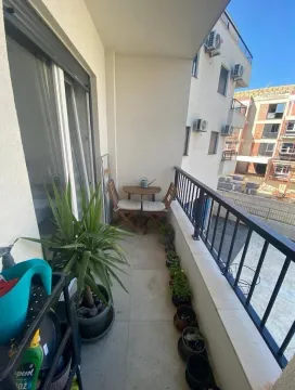 Namtješten balkon sa stolom, stolicama i saksijama sa cvijećem. - image 6
