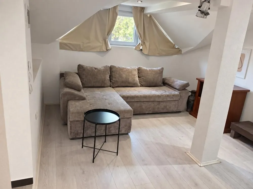 Attic living room with a sectional sofa and a small coffee table.