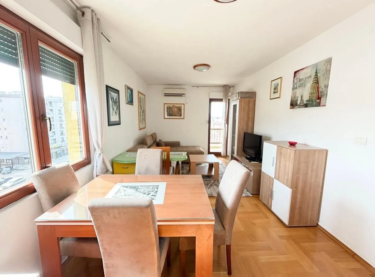 Living room with dining area and parquet flooring.