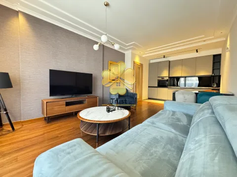 Modern living room with a sofa, TV, and an adjoining dining area. - image 3