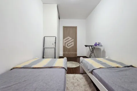 Bedroom with two single beds and white walls. - image 7