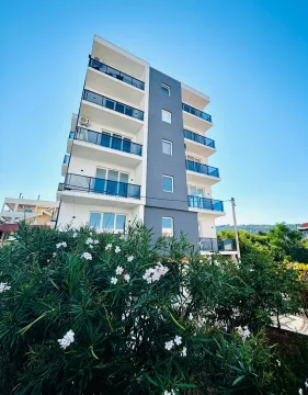 Spoljašnji izgled moderne stambene zgrade sa terasama i uređenim dvorištem. - image 3