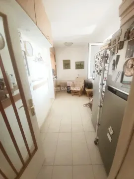 Corner of the kitchen with cabinets and a refrigerator. - image 7