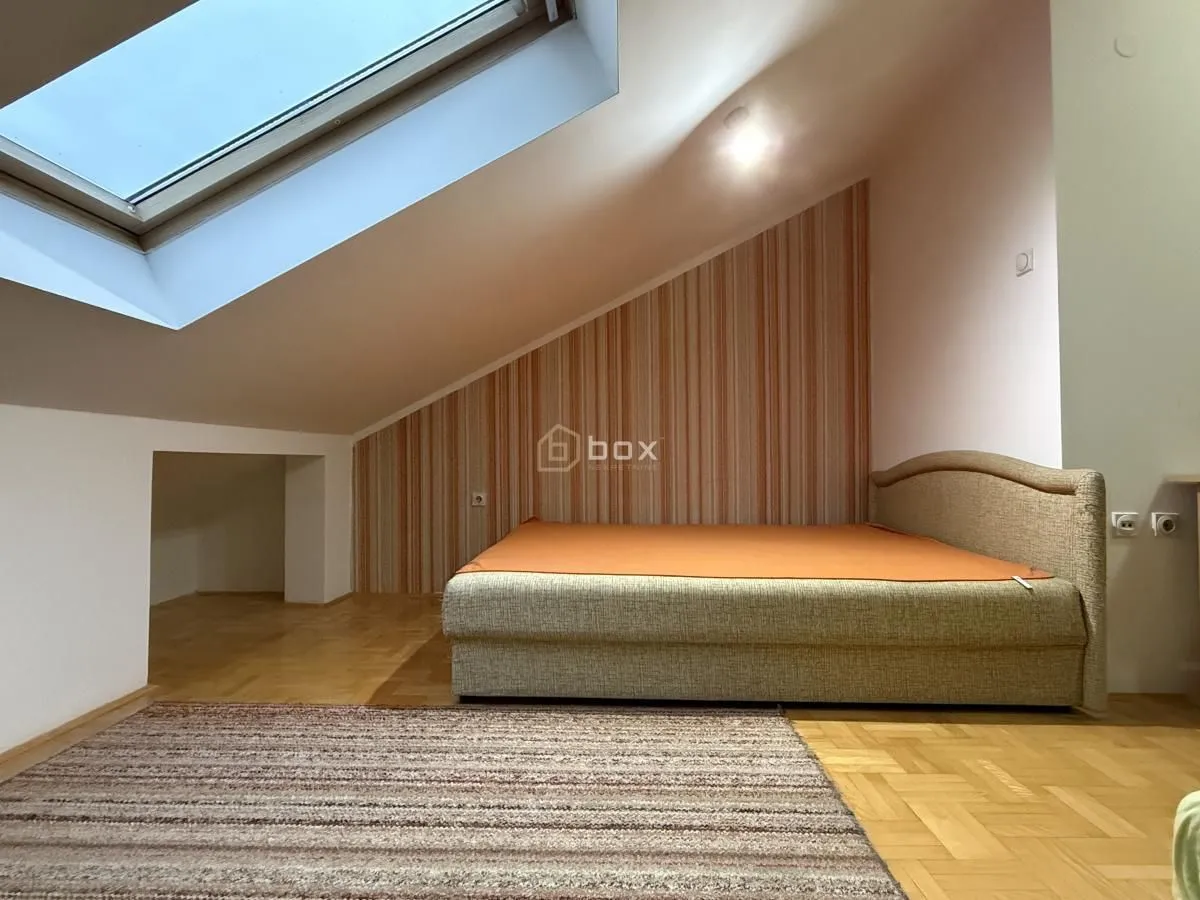 Attic bedroom furnished with a bed and a skylight.