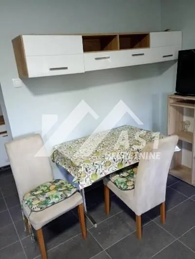 Dining table with chairs and wall-mounted cabinets in the living room.