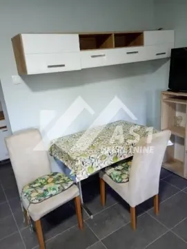 Dining table with chairs and wall-mounted cabinets in the living room. - image 2