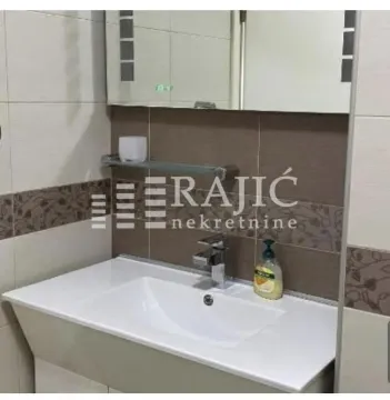 View of the bathroom with a sink, mirror, and tiles. - image 6