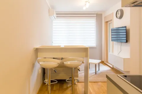 Living room with a dining table and chairs in a modern apartment. - image 3
